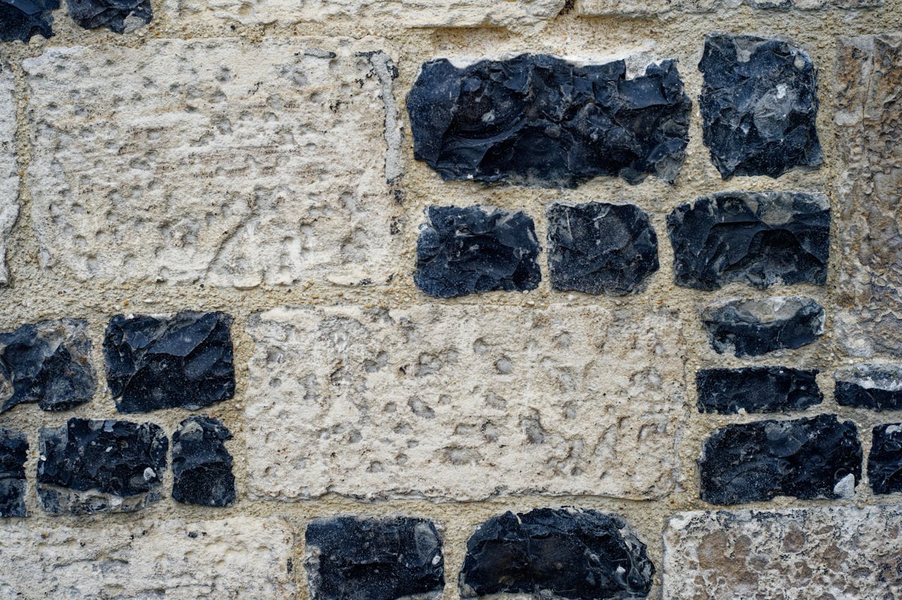 Close-up of a textured stone wall featuring dark flint inlays, ideal for backgrounds.