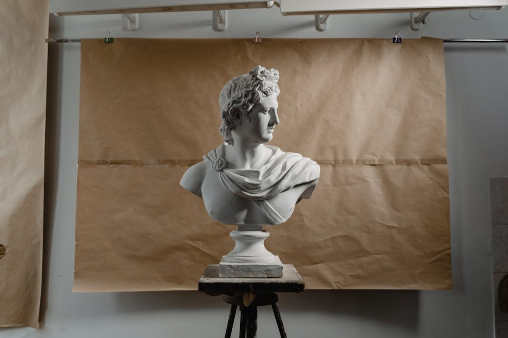 A classic sculpture bust displayed in an artist's studio against a paper backdrop, showcasing artistic craftsmanship.
